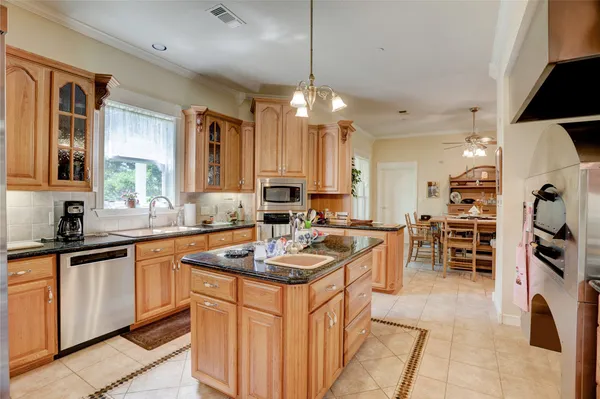 a kitchen that has a lot of cabinets a sink and appliances in it