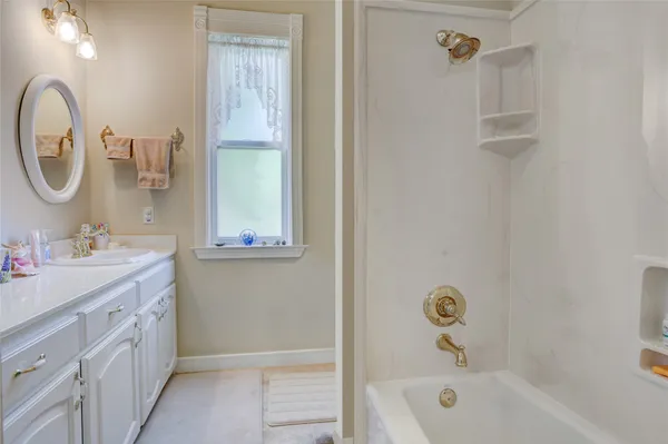 a bathroom with a tub sink and mirror