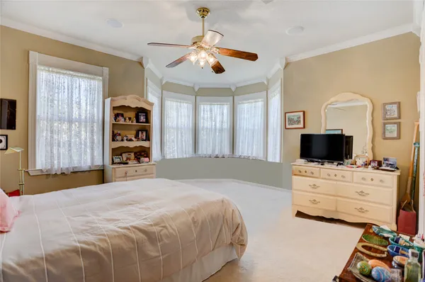 a bedroom with a bed a flat screen tv and dresser