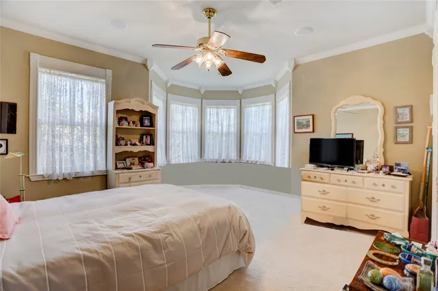 a bedroom with a bed a flat screen tv and dresser