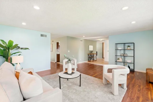 a living room with furniture and a wooden floor