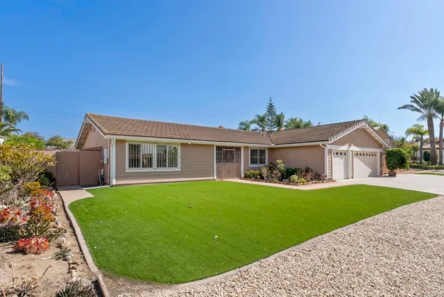a front view of house with a garden and yard