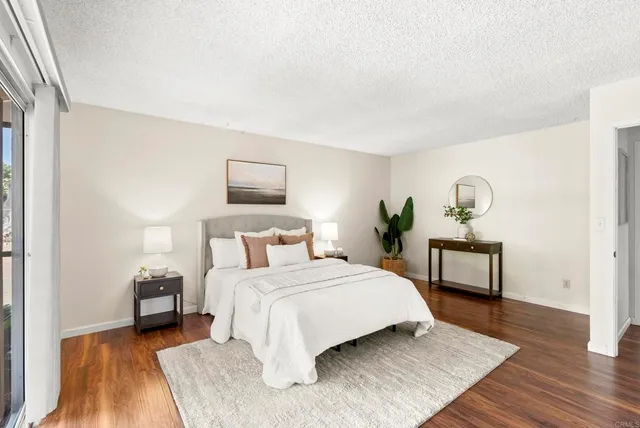 a bedroom with a bed and wooden floor