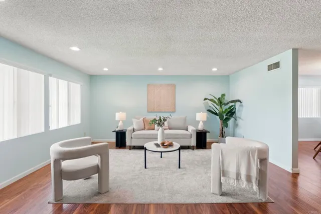 a living room with furniture and a wooden floor