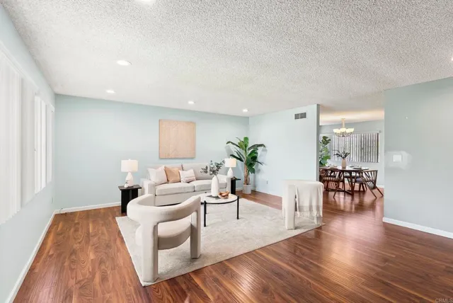 a living room with furniture and a wooden floor