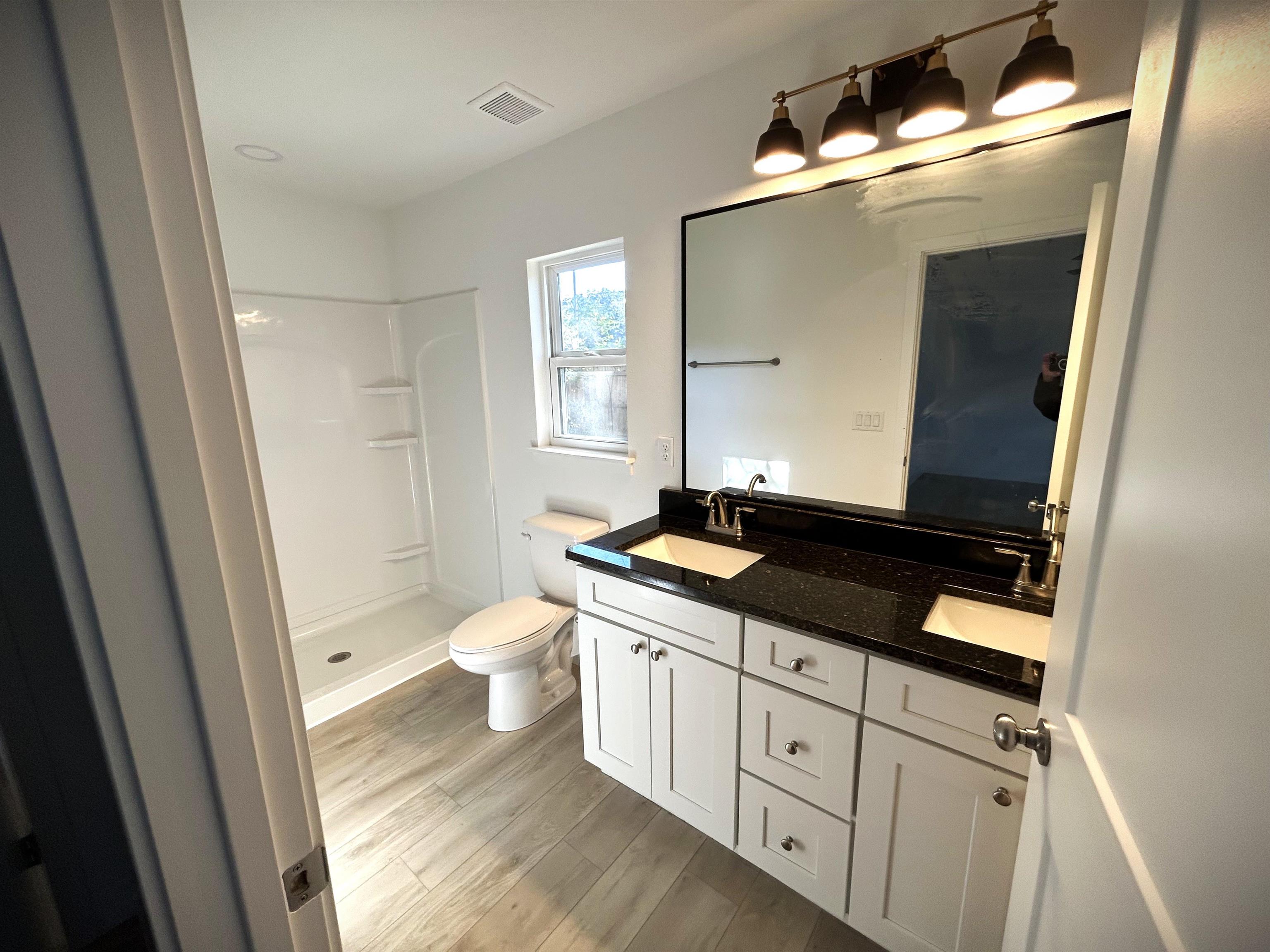3347 7th Street Elkton, FL 32033 - Photo 13 of 17 a bathroom with a granite countertop sink toilet a mirror and a vanity