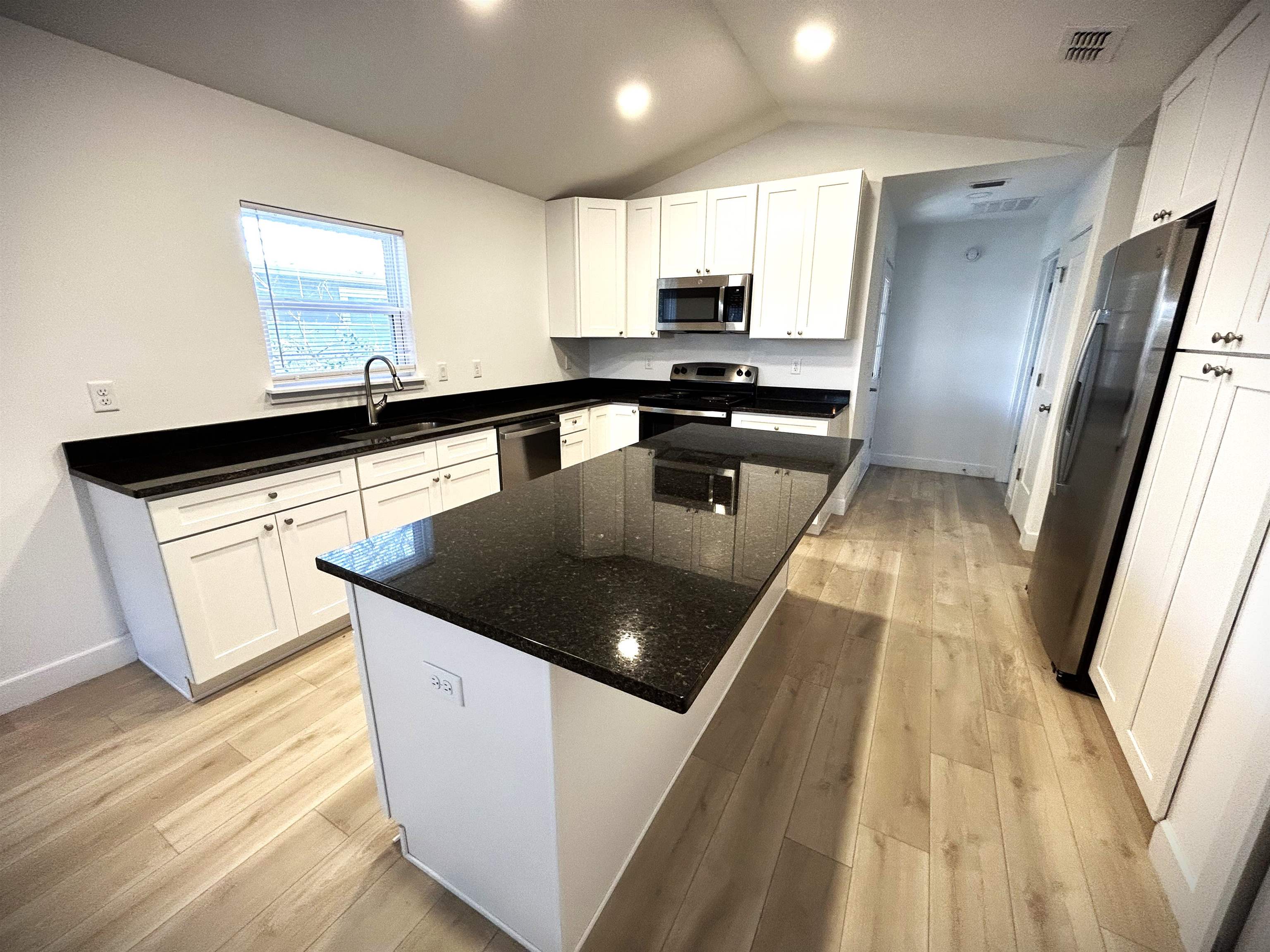 3347 7th Street Elkton, FL 32033 - Photo 3 of 17 a kitchen with stainless steel appliances granite countertop a sink a stove and a refrigerator