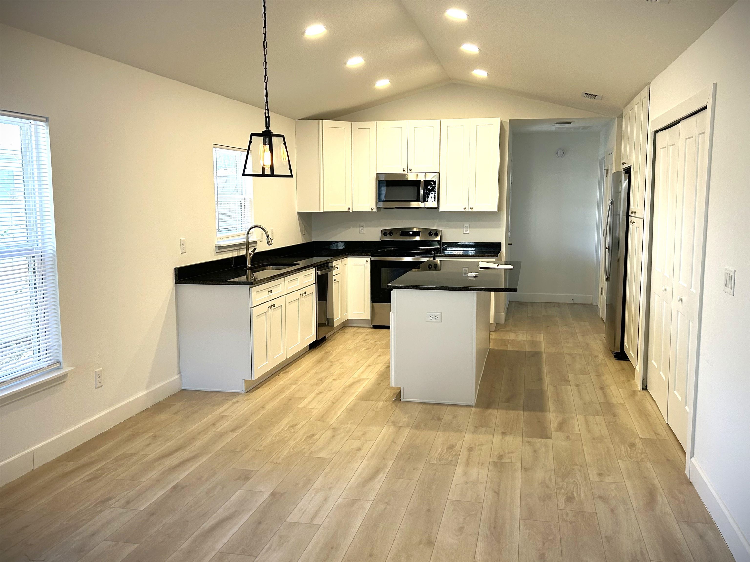 3347 7th Street Elkton, FL 32033 - Photo 5 of 17 a kitchen with stainless steel appliances granite countertop a sink a stove and a wooden floors