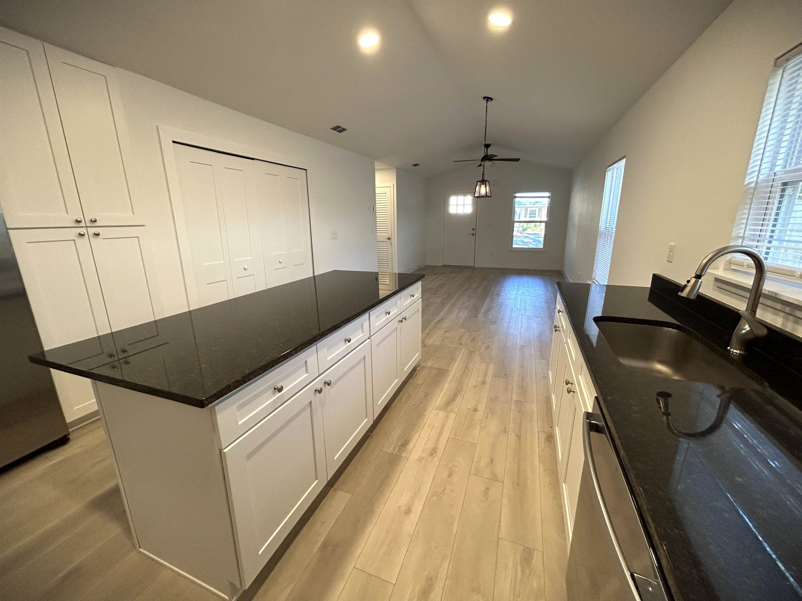 3347 7th Street Elkton, FL 32033 - Photo 7 of 17 a kitchen with granite countertop a sink a counter top space appliances and cabinets