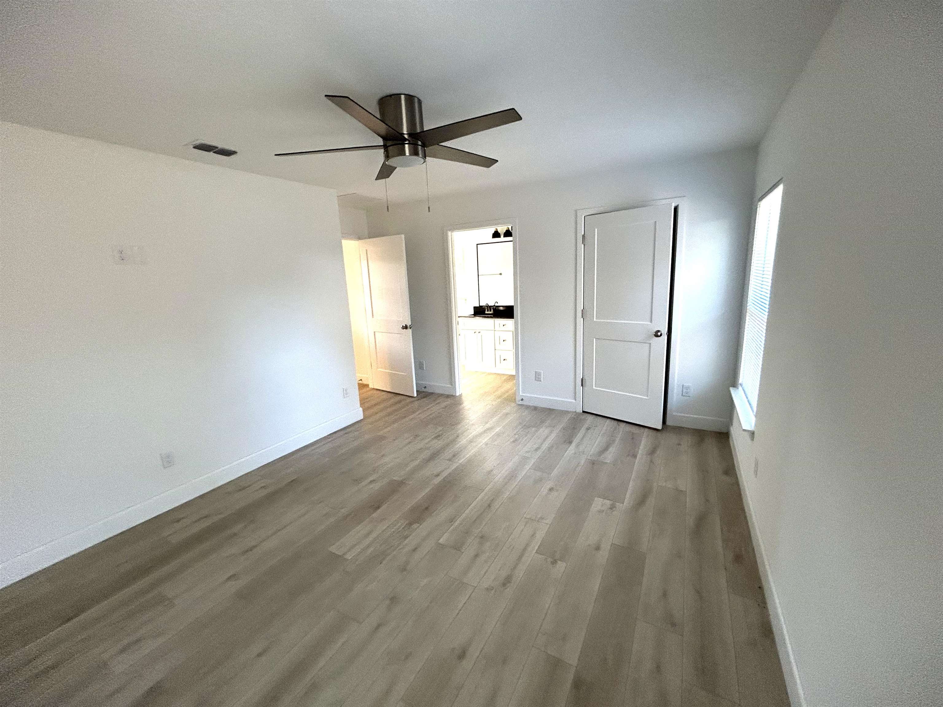 3347 7th Street Elkton, FL 32033 - Photo 9 of 17 wooden floor in an empty room with a window