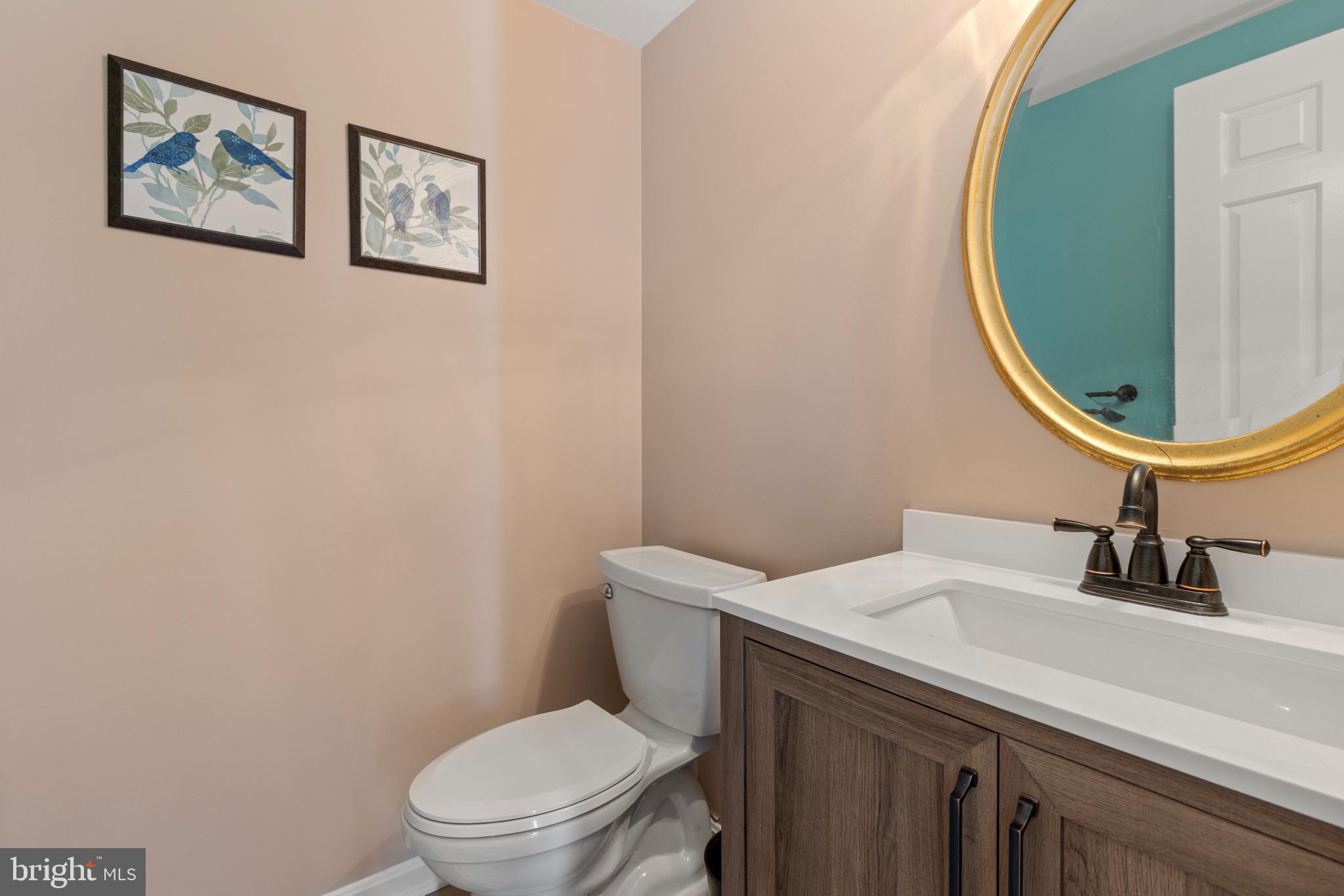 9209 Ramblebrook Road Baltimore, MD 21236 - Photo 21 of 54 a bathroom with a sink a toilet and a mirror