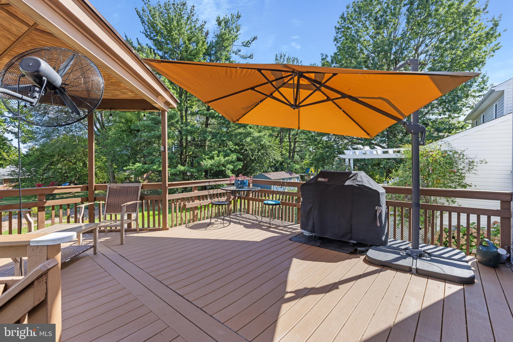 9209 Ramblebrook Road Baltimore, MD 21236 - Photo 45 of 54 a view of a roof deck with table and chairs under an umbrella with wooden floor