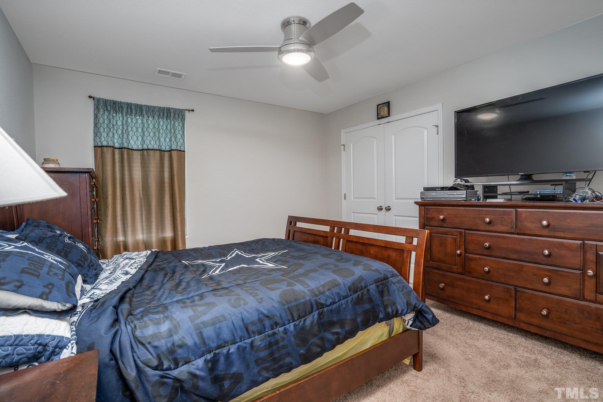 264 Rustling Way Zebulon, NC 27597 - Photo 20 of 22 a bedroom with a bed and a flat screen tv
