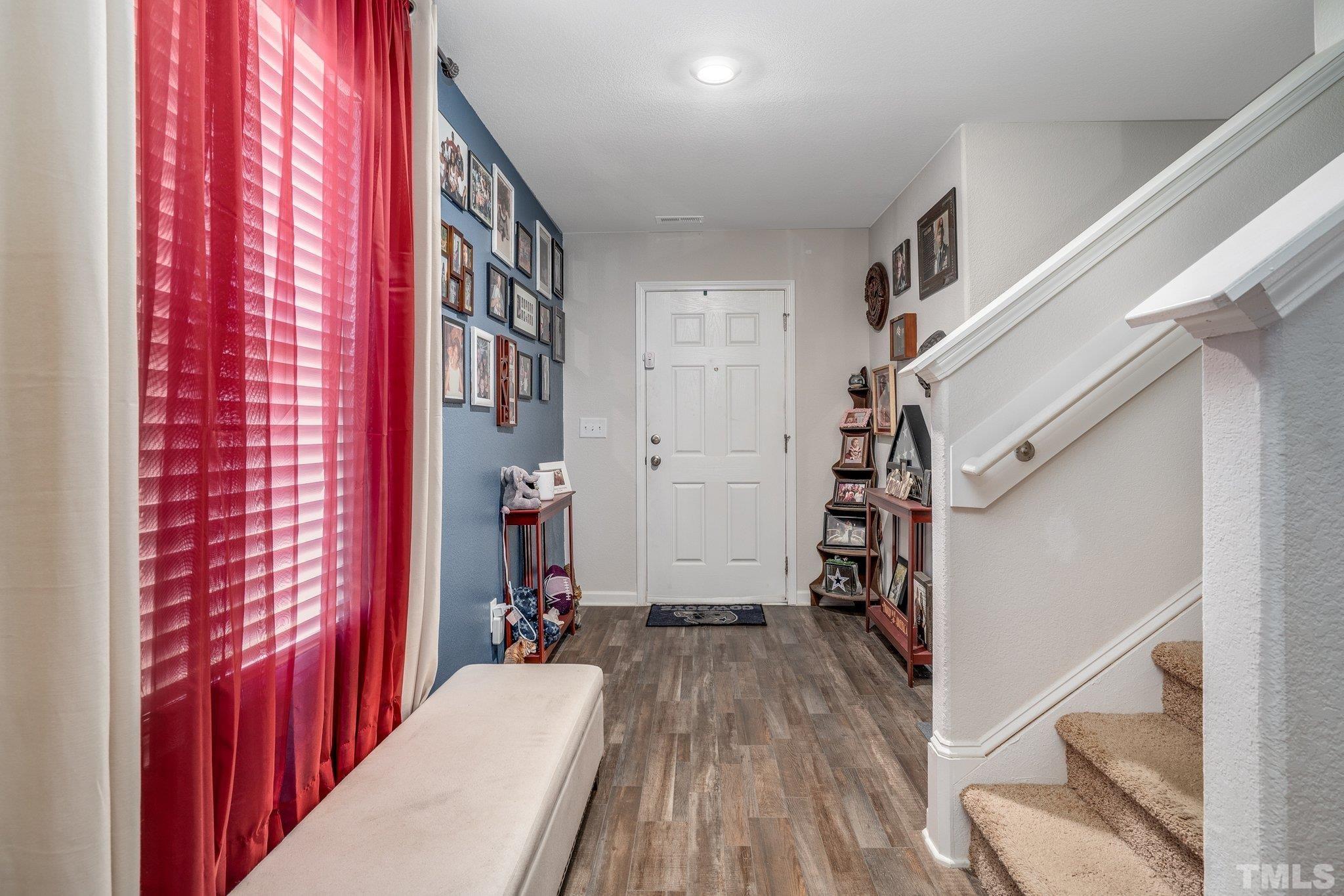 264 Rustling Way Zebulon, NC 27597 - Photo 5 of 22 a view of hallway with wooden floor and stairs