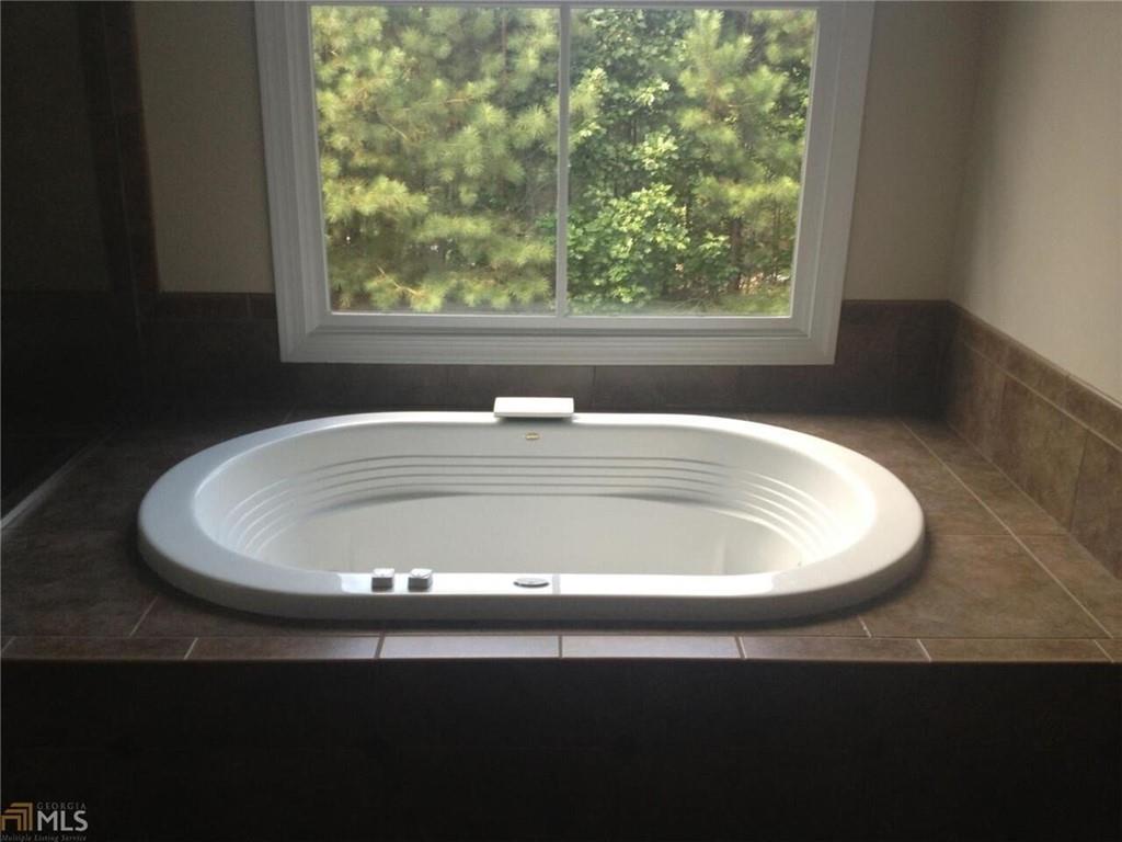 1059 Concerto Court Fairburn, GA 30213 - Photo 6 of 14 a white bath tub sitting in a bathroom