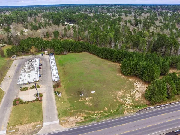 an aerial view of residential houses with outdoor space and trees