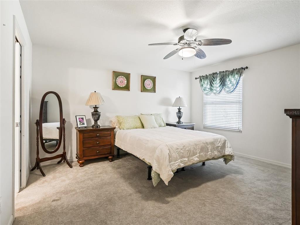 2360 Hopespring Loop The Villages, FL 32162 - Photo 16 of 30 a bedroom with a bed and a chandelier