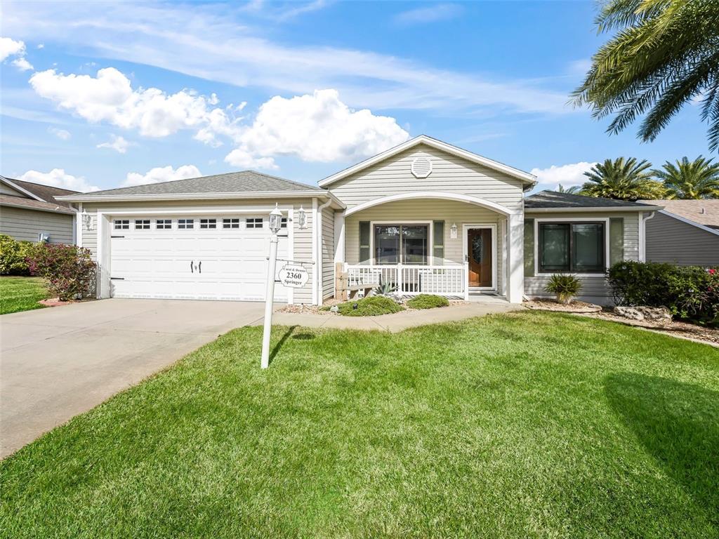 2360 Hopespring Loop The Villages, FL 32162 - Photo 2 of 30 a view of a white house with a big yard and potted plants