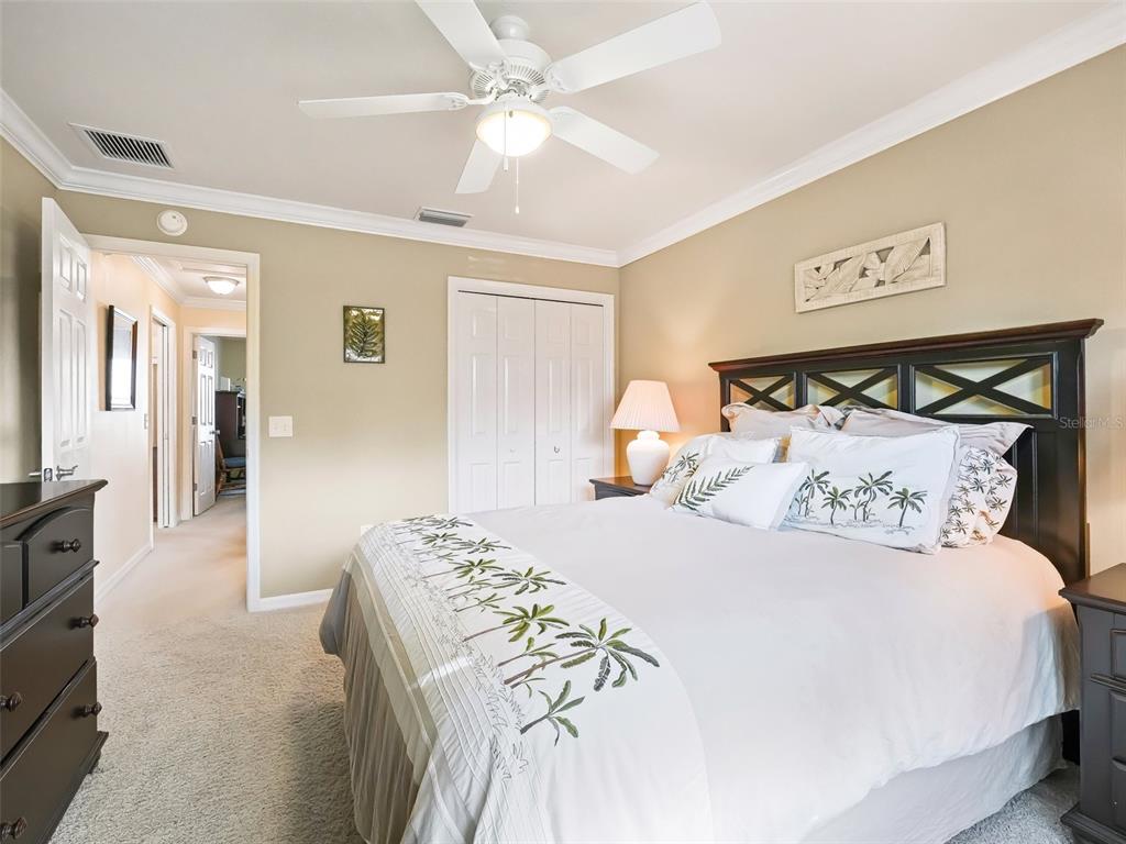 2360 Hopespring Loop The Villages, FL 32162 - Photo 22 of 30 a bedroom with a large bed and a chandelier
