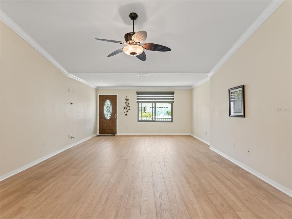 2360 Hopespring Loop The Villages, FL 32162 - Photo 7 of 30 a view of an empty room with wooden floor and a window