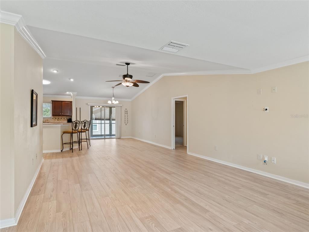 2360 Hopespring Loop The Villages, FL 32162 - Photo 8 of 30 a view of empty room with wooden floor and a ceiling fan