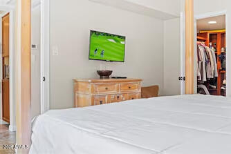 7625 East Camelback Road, Unit B228 Scottsdale, AZ 85251 - Photo 16 of 24 a bedroom with a bed and a flat tv screen on dresser