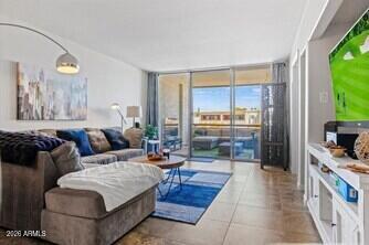 7625 East Camelback Road, Unit B228 Scottsdale, AZ 85251 - Photo 7 of 24 a living room with furniture and a floor to ceiling window