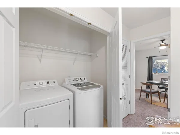 a utility room with dryer washer and a view of living area