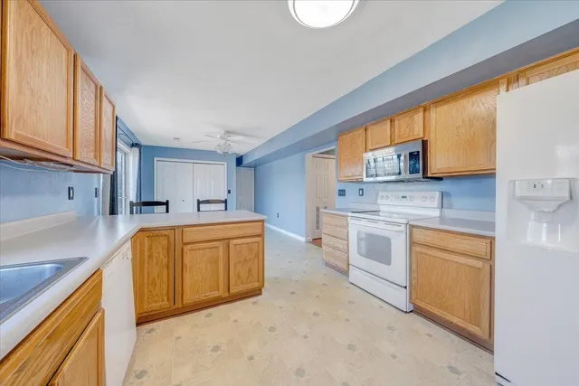 a kitchen with stainless steel appliances granite countertop a sink a stove a refrigerator with grey cabinets