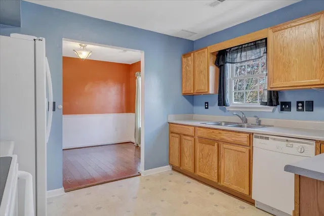 a kitchen with stainless steel appliances granite countertop a sink and a refrigerator