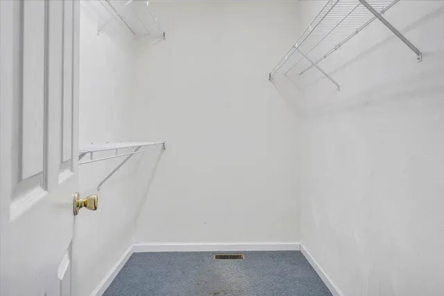 a view of an empty room with window and chandelier fan