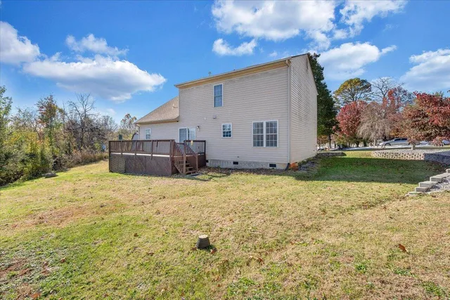 a view of a house with a big yard and large tree