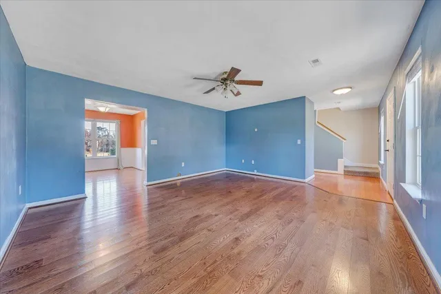 a view of a room with wooden floor and a ceiling fan