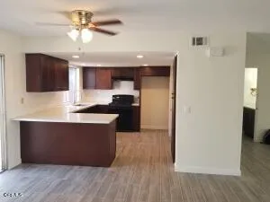 a kitchen with stainless steel appliances wooden floor and a refrigerator