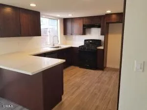 a kitchen with granite countertop a refrigerator and a stove top oven