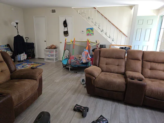 a living room with furniture and a wooden floor