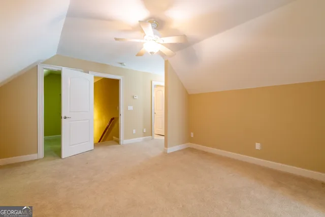 an empty room with a bathroom and chandelier