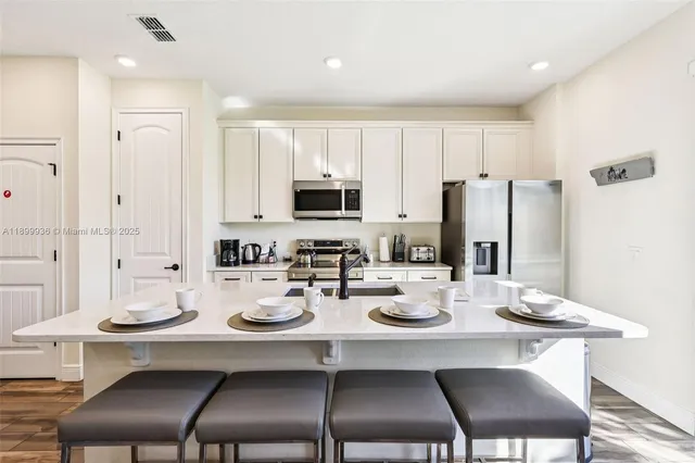a kitchen with refrigerator dining table and chairs