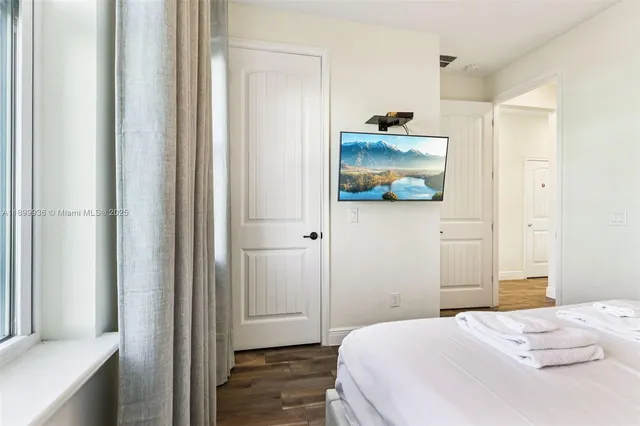 a bedroom with a bed and wooden floor