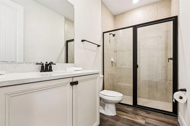 a bathroom with a shower sink vanity and toilet