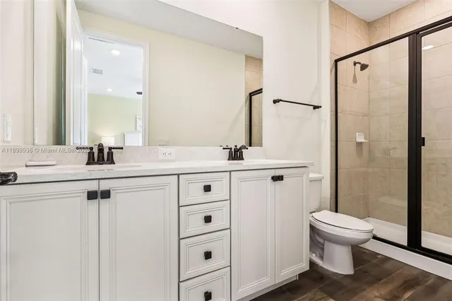 a bathroom with a double vanity sink toilet and shower