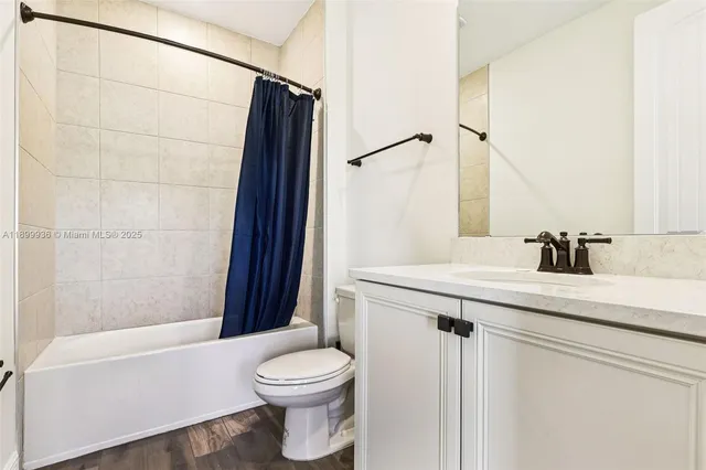 a bathroom with a sink a toilet a mirror and shower