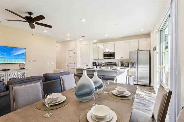 a kitchen with stainless steel appliances kitchen island granite countertop a dining table and chairs