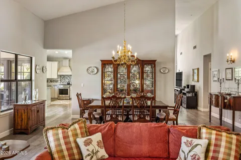 a living room with furniture a chandelier and a dining table