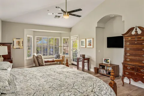 a bedroom with a bed a flat screen tv and dresser