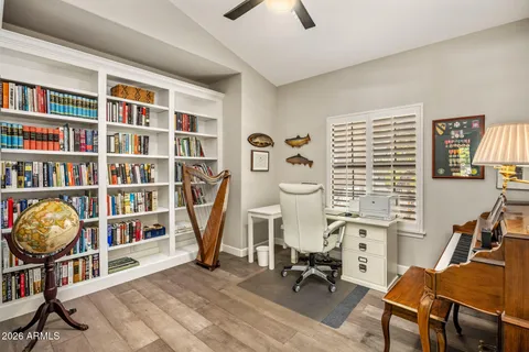 a view of a workspace with furniture and a bookshelf
