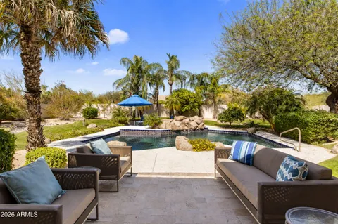 a view of a swimming pool with couches and lounge chairs