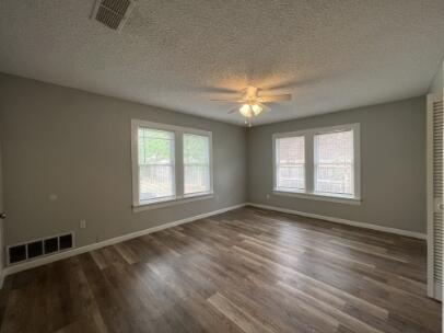 2318 18th Street Lubbock, TX 79401 - Photo 11 of 21 a view of an empty room with wooden floor and a window