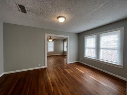 2318 18th Street Lubbock, TX 79401 - Photo 16 of 21 an empty room with wooden floor and windows
