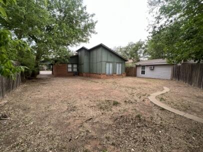 2318 18th Street Lubbock, TX 79401 - Photo 21 of 21 a backyard of a house with large trees and wooden fence